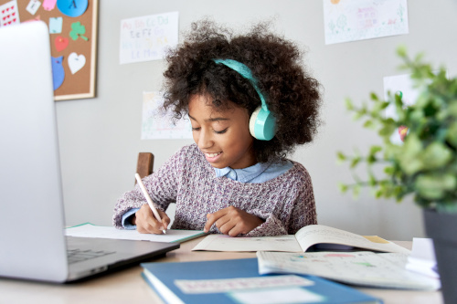 African school kid girl wearing headphones virtual distance learning at ...